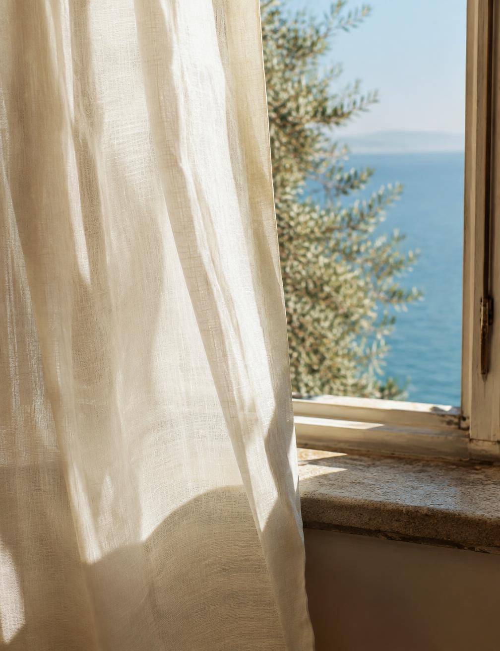 Linen curtain moving in soft light by an open window